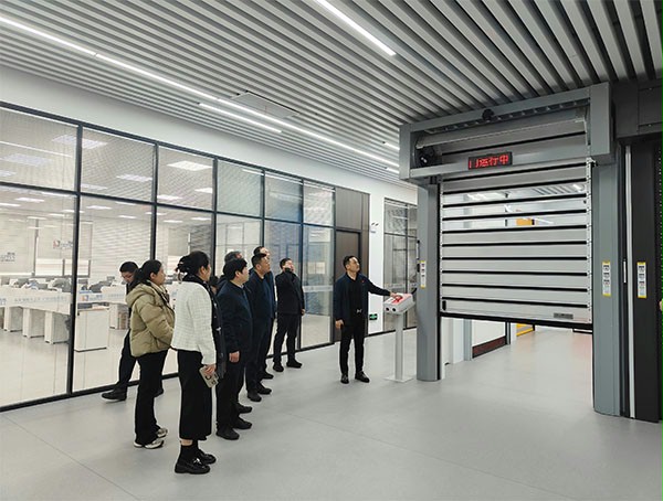 上图为：蘑菇视频免费网站门业董事长杨元嘉为领导们演示高端工业门产品在工业物联网中的应用
